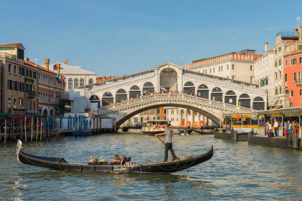 tour en gondole avec touriste près du pont du rialto à venise, italie. - venice italy rialto bridge bridge veneto photos et images de collection