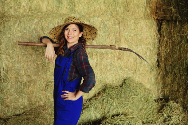 istock Woman farmer working with hay fork 1142028008