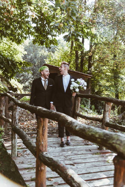 couple gay marchant ensemble dans le parc pour le mariage - homosexual wedding married engagement photos et images de collection