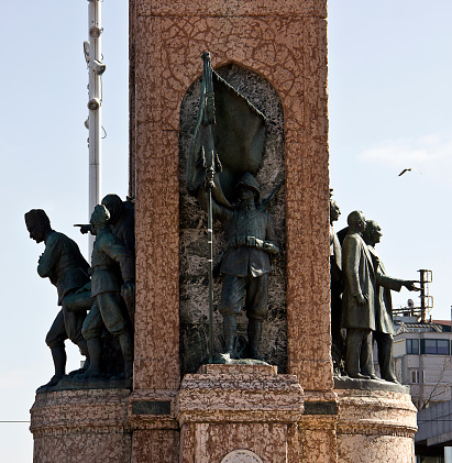 Istanbul, Turkey, February 17, 2019: Monument of Republic is sculpted by the Italian sculptor Pietro Canonica in 1928, Rome, Italy. Monument named 'Cumhuriyet Anıtı' to founder of Turkish Republic 'Atatürk' at Taksim square in Istanbul. People hang around it.