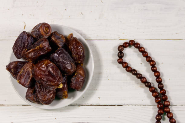 istock Dates fruit and prayer beads on white wooden table. Top view 1142039226