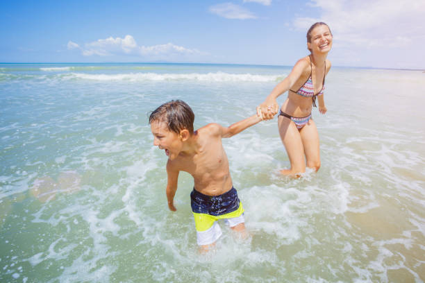 istock Happy kids having fun on tropical beach 1142044137