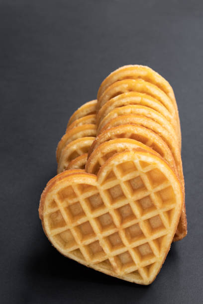 istock Stacks of heart shaped waffles on black background 1142048894