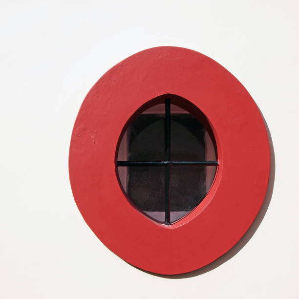 An ornate, beautiful old attic circular window on a historic European building, showcasing early 20th century architecture