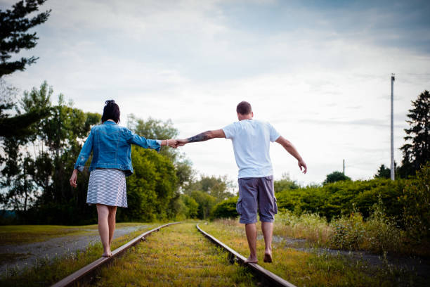 istock Couple walking on a railroad track 1142060140