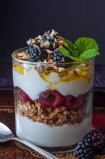 Greek yogurt with raspberries, blackberries, crushed almonds, granola and honey