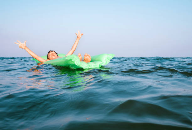 istock happy boy swims on green inflatable mattress 1142090720