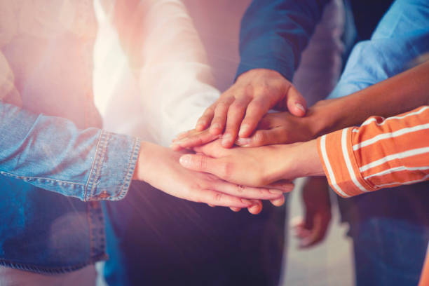 istock Group of workers holding hands in celebration. Collaboration concept. 1142090759