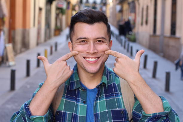 Man forced to smile outdoors Man forced to smile outdoors. cheesy grin photos stock pictures, royalty-free photos & images