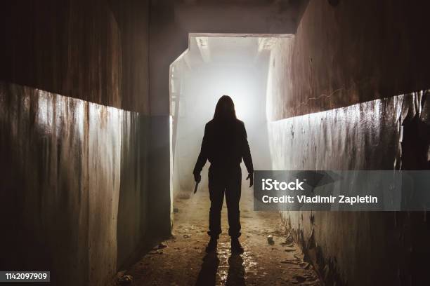 Creepy Silhouette With Knife In The Dark Abandoned Building Horror About Maniac Concept Stock Photo - Download Image Now