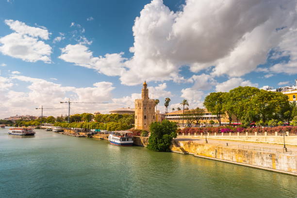 View of Golden Tower, Torre del Oro, of Seville, Andalusia, Spain View of Golden Tower, Torre del Oro, of Seville, Andalusia, Spain over river Guadalquivir at sunset. Clouds over historic buildings. mozarabic stock pictures, royalty-free photos & images