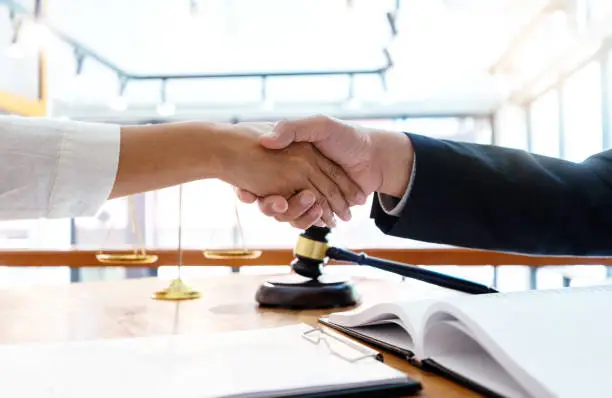 Photo of Lawyer or judge  with gavel and balance handshake with client