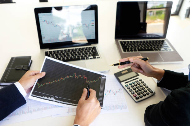 istock business man and woman sit at ther table looking at computer laptop 1142104178