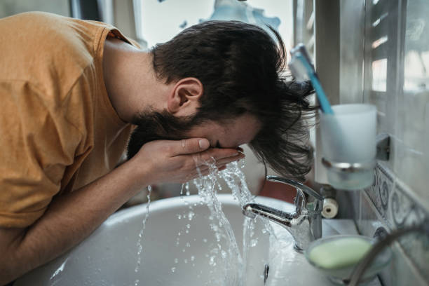 istock Man cleaning his face in the morning 1142105215
