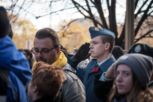 soldat der kanadischen royal air force, der einen militärischen gruß und das tragen von membranen macht, steht auf zeremonie zum gedenktag - canadian soldier stock-fotos und bilder