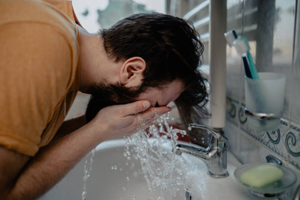istock Man cleaning his face in the morning 1142105330