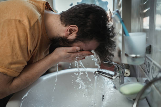 istock Man cleaning his face in the morning 1142105343