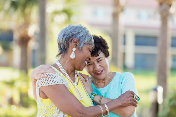 istock Multi-ethnic senior women laughing, hands on shoulders 1142106731