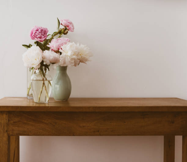 pink and white peonies in vases on wooden side table - side table imagens e fotografias de stock