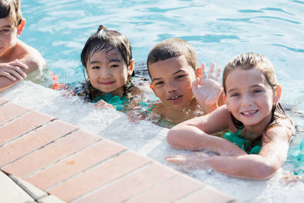 istock Three multi-ethnic children having fun in swimming pool 1142108395