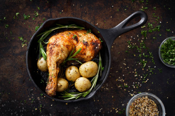 Chiken leg and potatoes in a skillet Roasted chicken leg and small potatoes with seasoning in cast iron skillet cooking pan overhead stock pictures, royalty-free photos & images