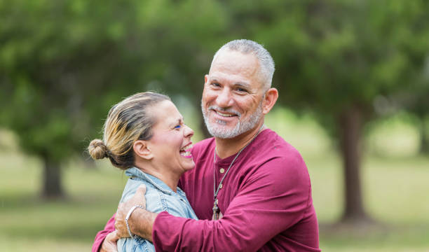 istock Mature Hispanic couple embracing in park, laughing 1142111874