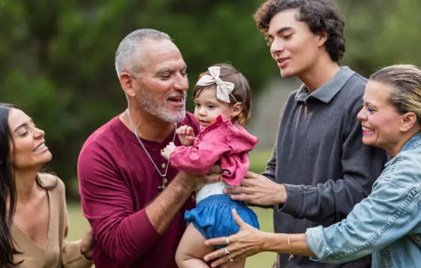 Photo of Multi-generation Hispanic family, grandpa holding baby