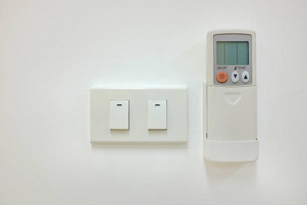 istock Electric switch and air conditioner remote control on the white wall. 1142125078