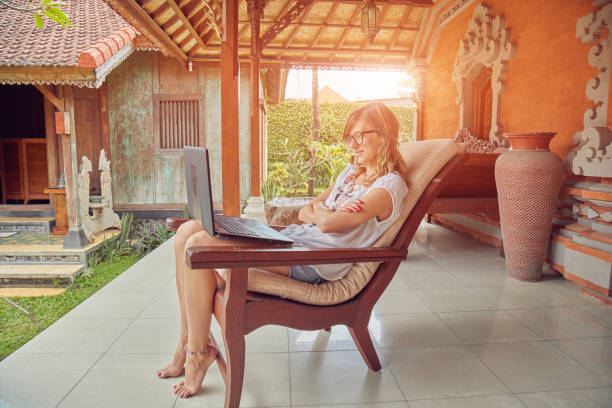 istock Girl using laptop on a home porch / terrace. 1142136630