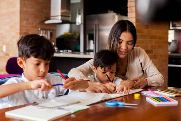 Homework of the children A mother and her latin children of different ages are helping their children with the homework they left at school latin script stock pictures, royalty-free photos & images