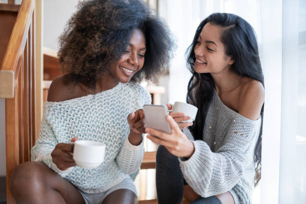 istock Girlfriends drinking coffee and using smart phone, in hotel room. 1142137581
