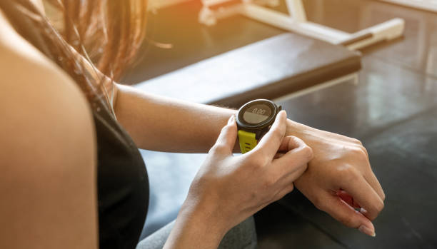 schließen sie die hand der jungen frau mit intelligenter uhr und applikationstraining im fitnessstudio für einen guten gesunden lebensstil. technik und sportkonzept. - checking the time watch women looking stock-fotos und bilder