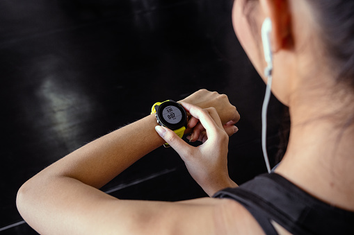 Young woman workout in gym healthy lifestyle using smart watch and application. Technology and sport concept.