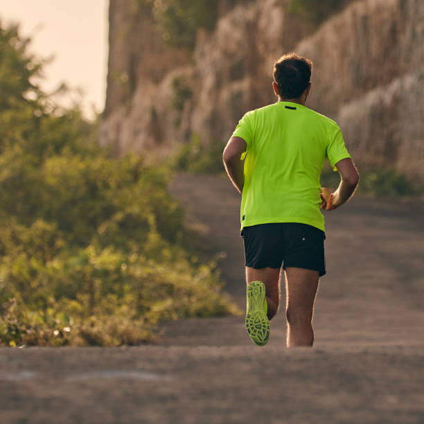 istock Man jogging on a downhill / uphill in suburb mountain road. 1142137892
