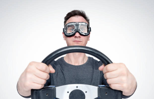 istock Confident man in stylish goggles with steering wheel, car driver concept 1142137920