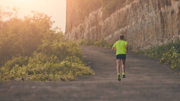 istock Man jogging on a downhill / uphill in suburb mountain road. 1142137964