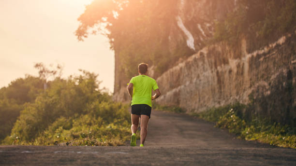 istock Man jogging on a downhill / uphill in suburb mountain road. 1142138028
