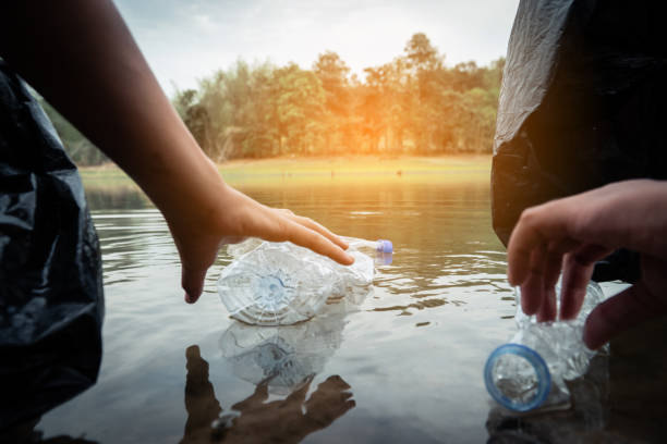 istock The volunteer picking up a bottle plastic in the river , protect environment from a water pollution concept. 1142139144