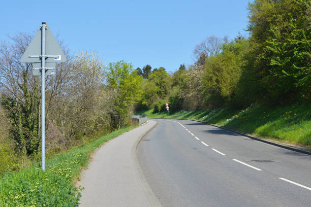istock Curvy highway with narrow footpath at the side surrounded by trees leading up the German Odenwald moutain range 1142142107