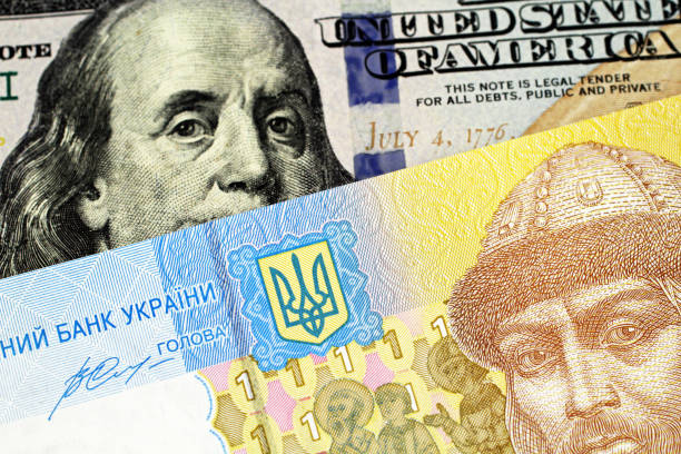 A one Ukrainian hryvnia bank note with an American one hundred dollar bill A blue and yellow one hryvnia bank note from Ukraine with a blue one hundred American dollar bill close up in macro ukrainian currency stock pictures, royalty-free photos & images