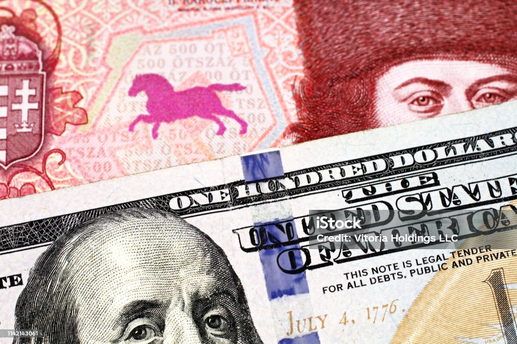 A red Hungarian forint bank note with an American one hundred dollar bill A red, five hundred Hungarian forint bank note with a blue American one hundred dollar bill close up in macro American One Hundred Dollar Bill Stock Photo