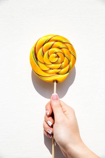 Lollypop on a stick ina hand.
