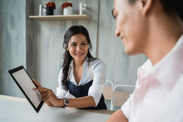 istock female waitress offering the new menu to customer 1142149828