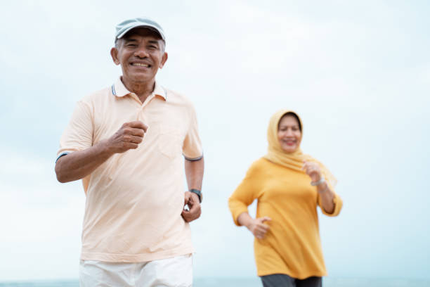 muslim old couple workout and running at the beach portrait of muslim old couple workout and running at the beach together malay couple stock pictures, royalty-free photos & images