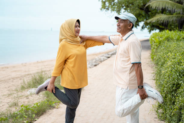 istock senior man and woman support each other while stretching 1142151452