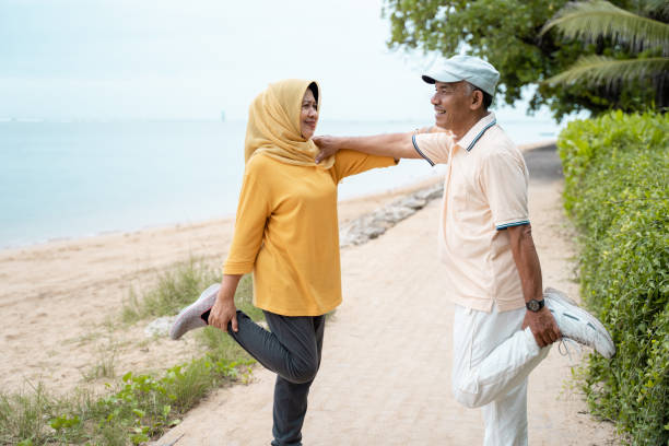 istock senior man and woman support each other while stretching 1142151482