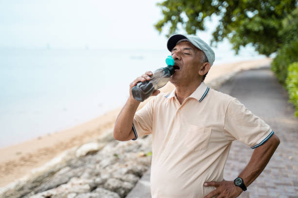 istock senior male asian drinking water bottle 1142151543