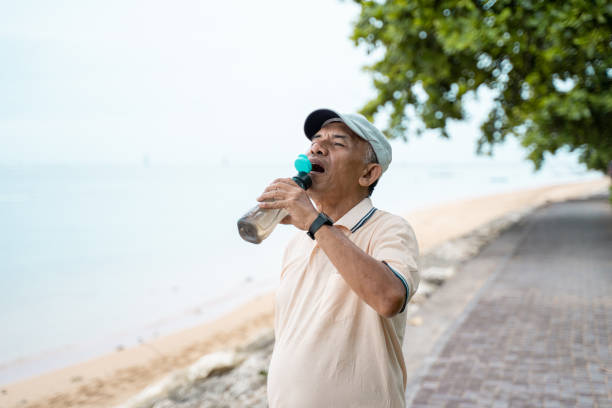 istock senior male asian drinking water bottle 1142151571