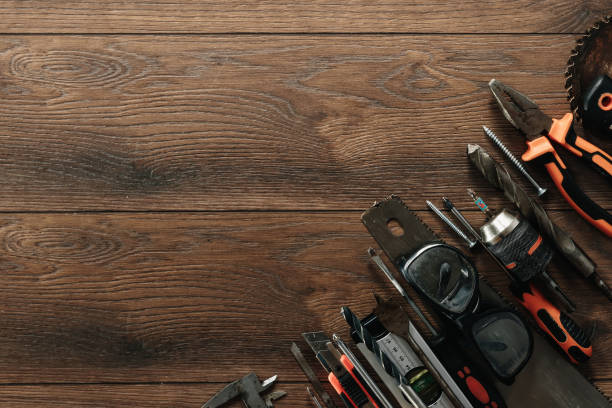 istock A construction tool on a brown wooden background. View from above. Picture background, screensaver. The concept of construction, repair, construction, production, design. Copy space. 1142152987