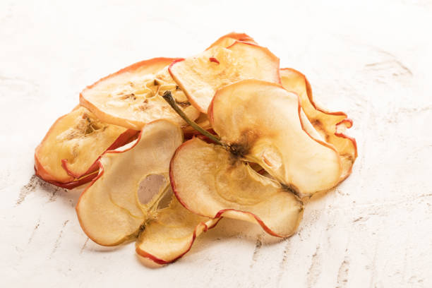 istock Heap of dried apple chips on white textured background. 1142154041